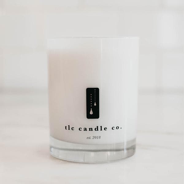 Amber Noir Sandalwood soy candle by DC-TLC Candle Co. in a glass container with a lit wick and warm amber and sandalwood fragrance.
