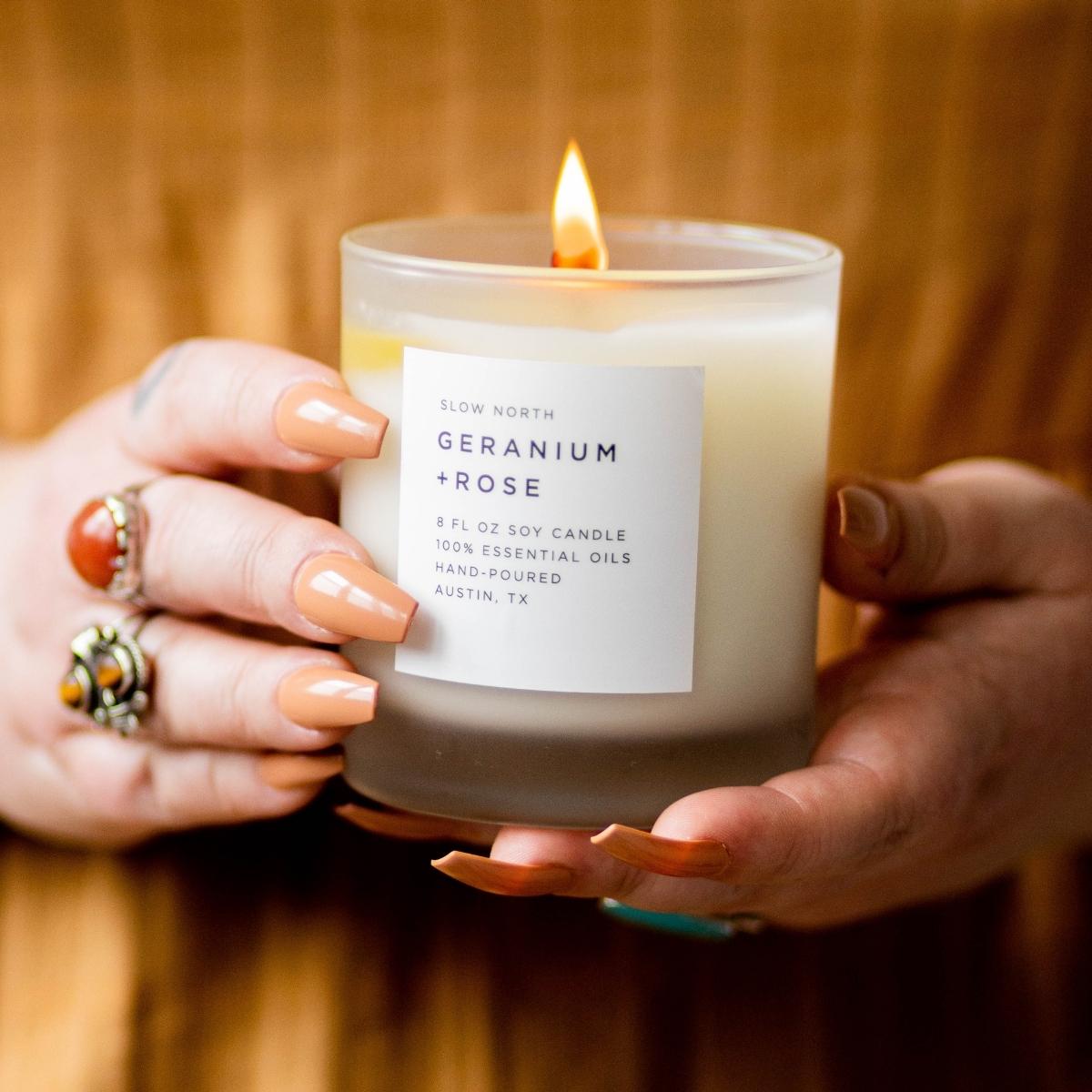 8oz Geranium and Rose scented candle by DC-Slow North with a clear glass jar and elegant floral design.