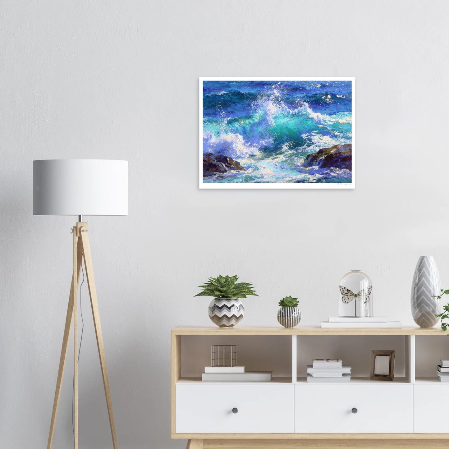Framed artwork of a seascape on a wall above a wooden console table with decorative items.