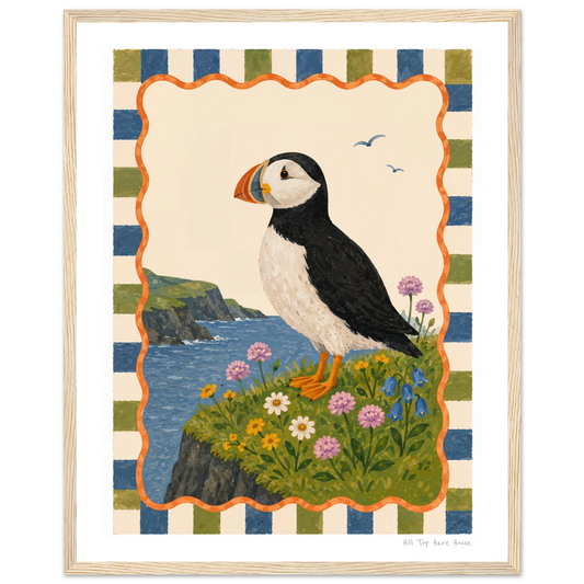Framed artwork of a puffin on a cliff with flowers and striped border
