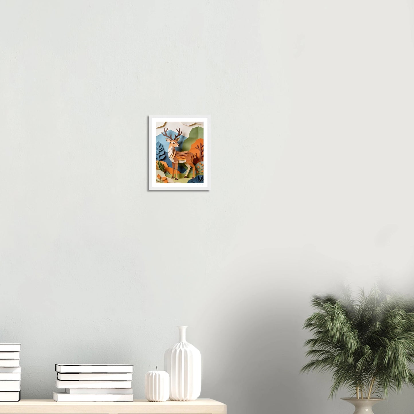 Framed artwork of a mountain landscape with a sunset on a white wall.