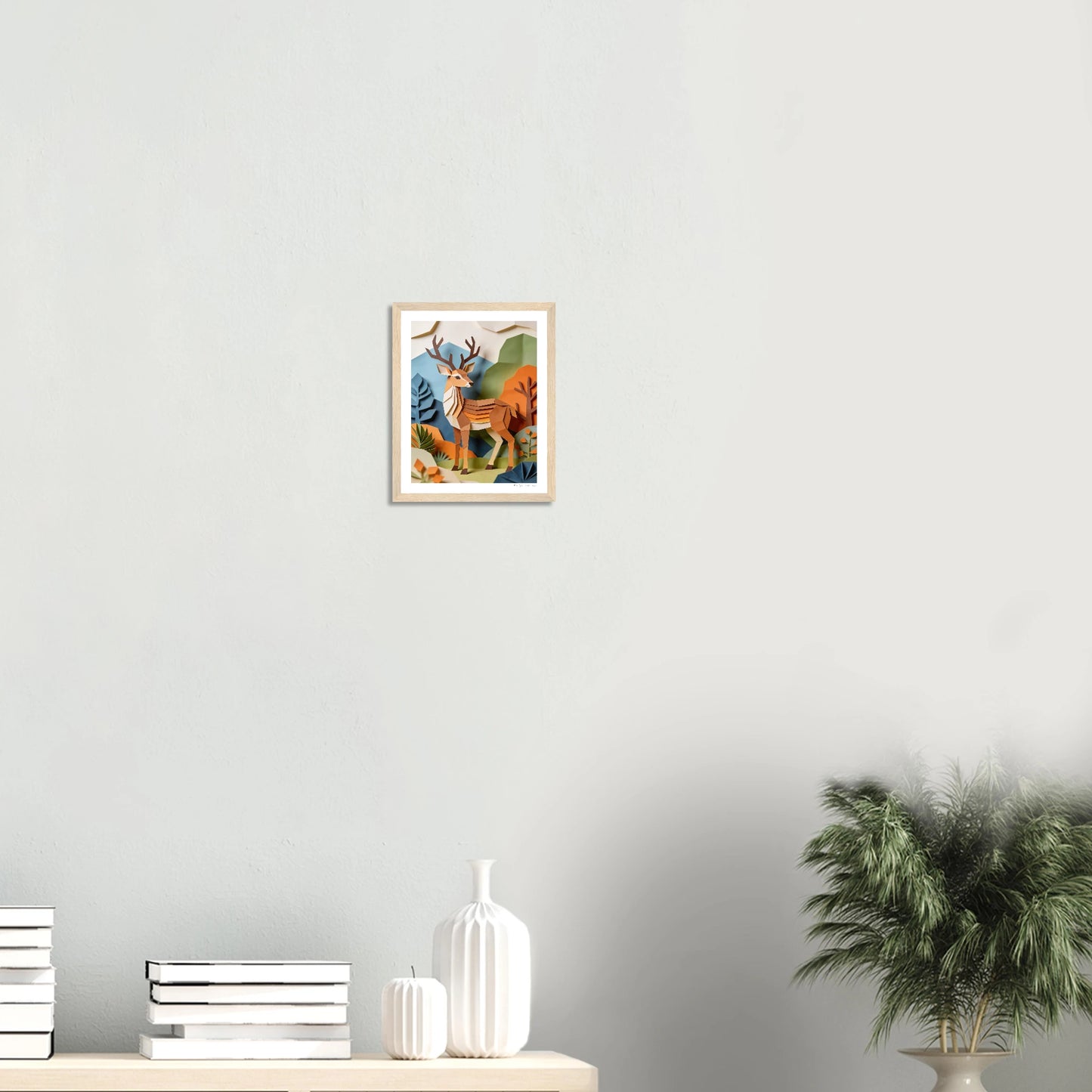Framed artwork of a mountain landscape with a sunset on a white wall.
