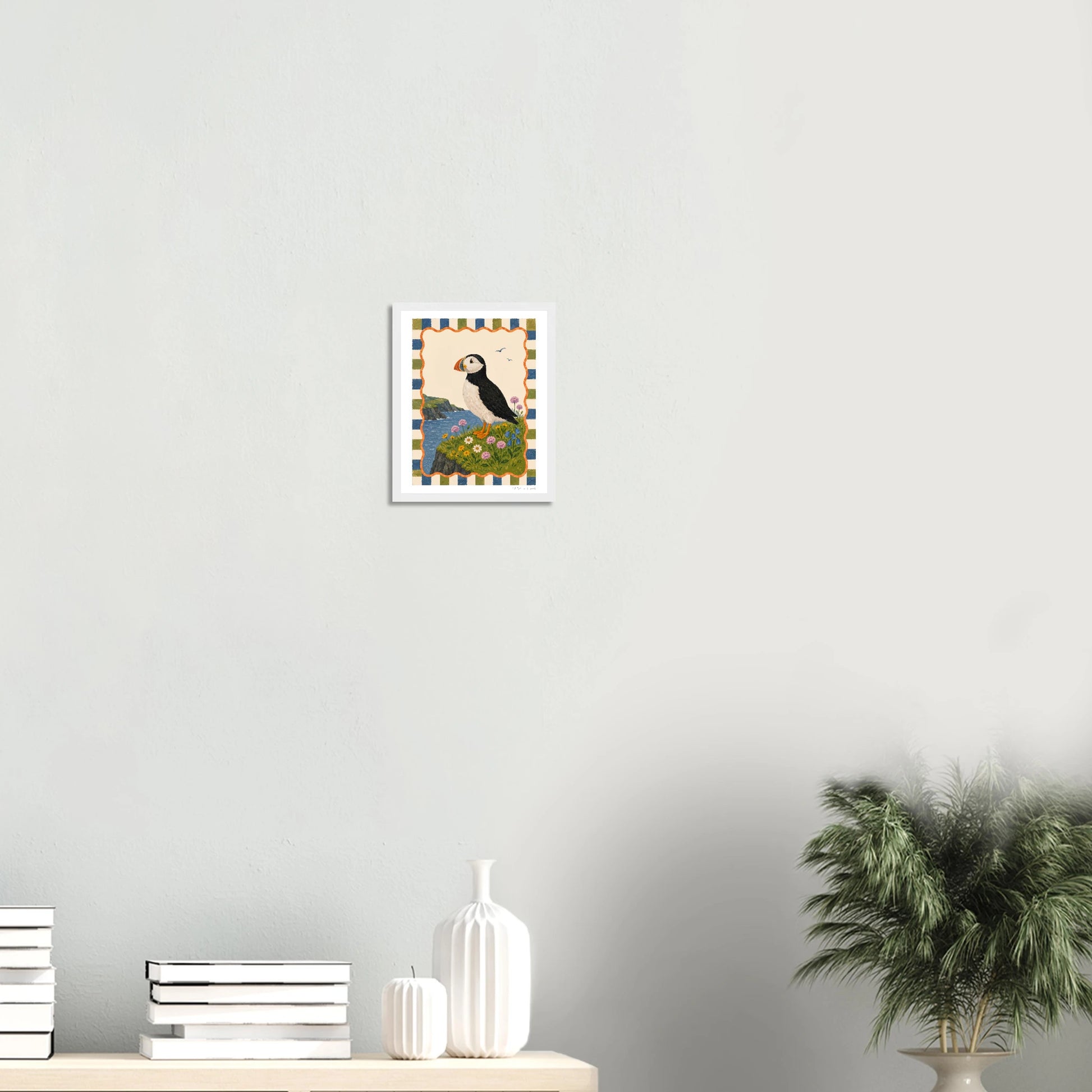 Framed artwork on a wall with decorative items below