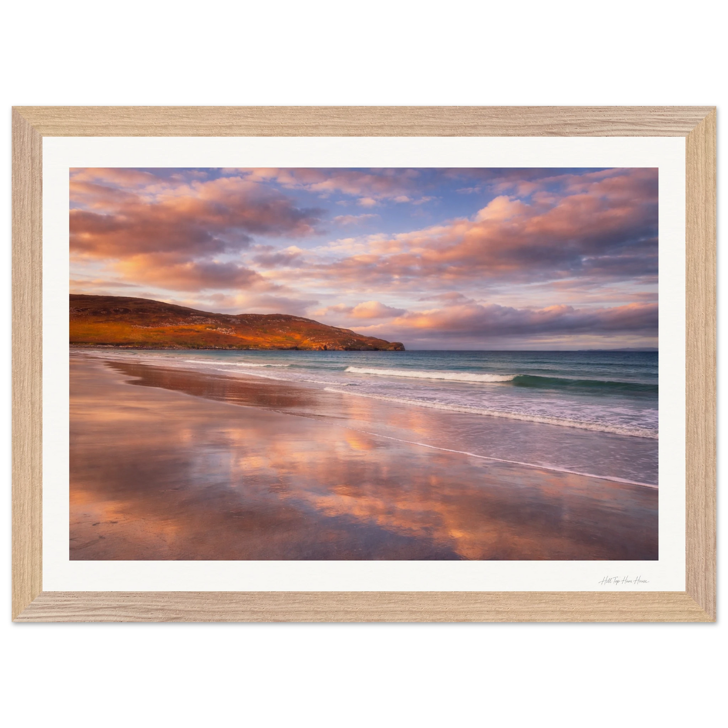Framed artwork of a beach scene with a sunset reflection on the water.