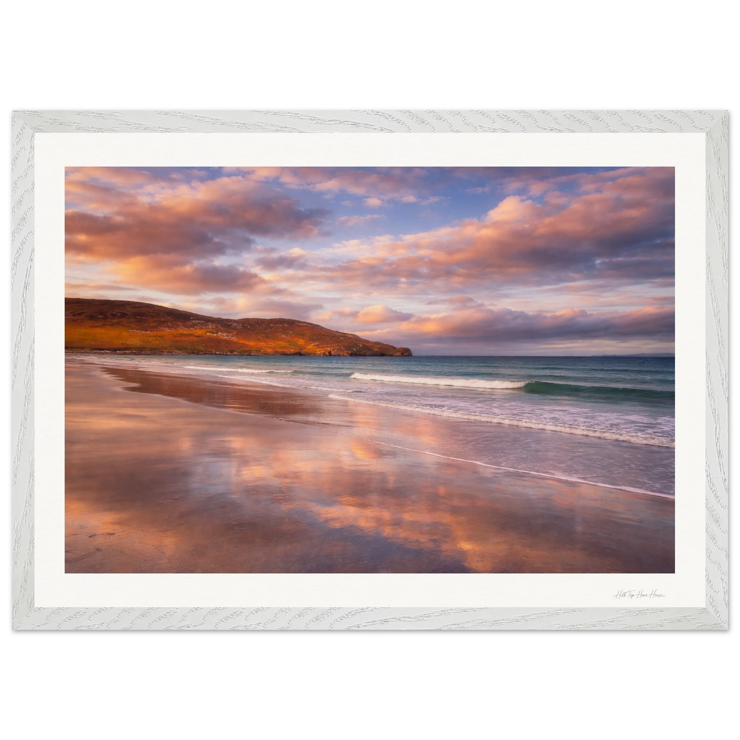 Framed artwork of a beach scene with a sunset sky.