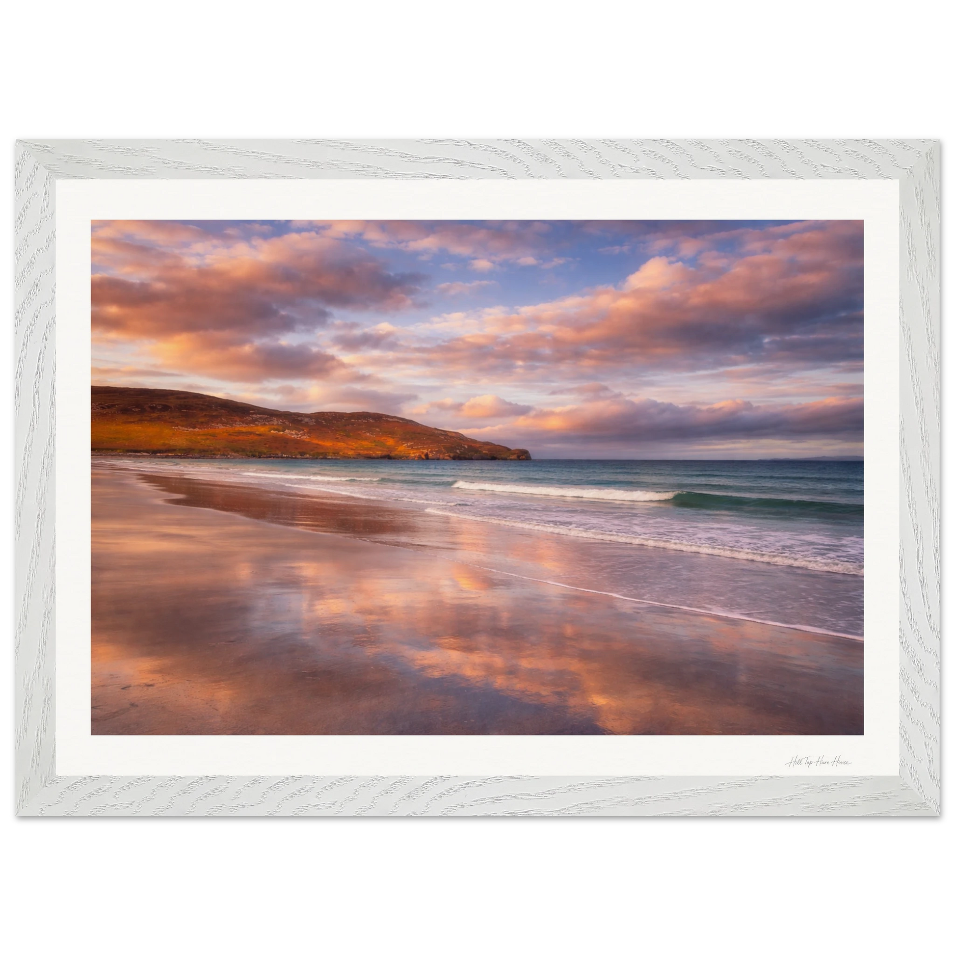 Framed artwork of a beach scene with a sunset sky.