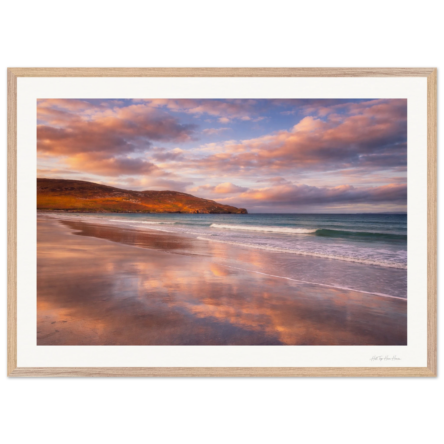 Framed artwork of a beach scene with a sunset sky.