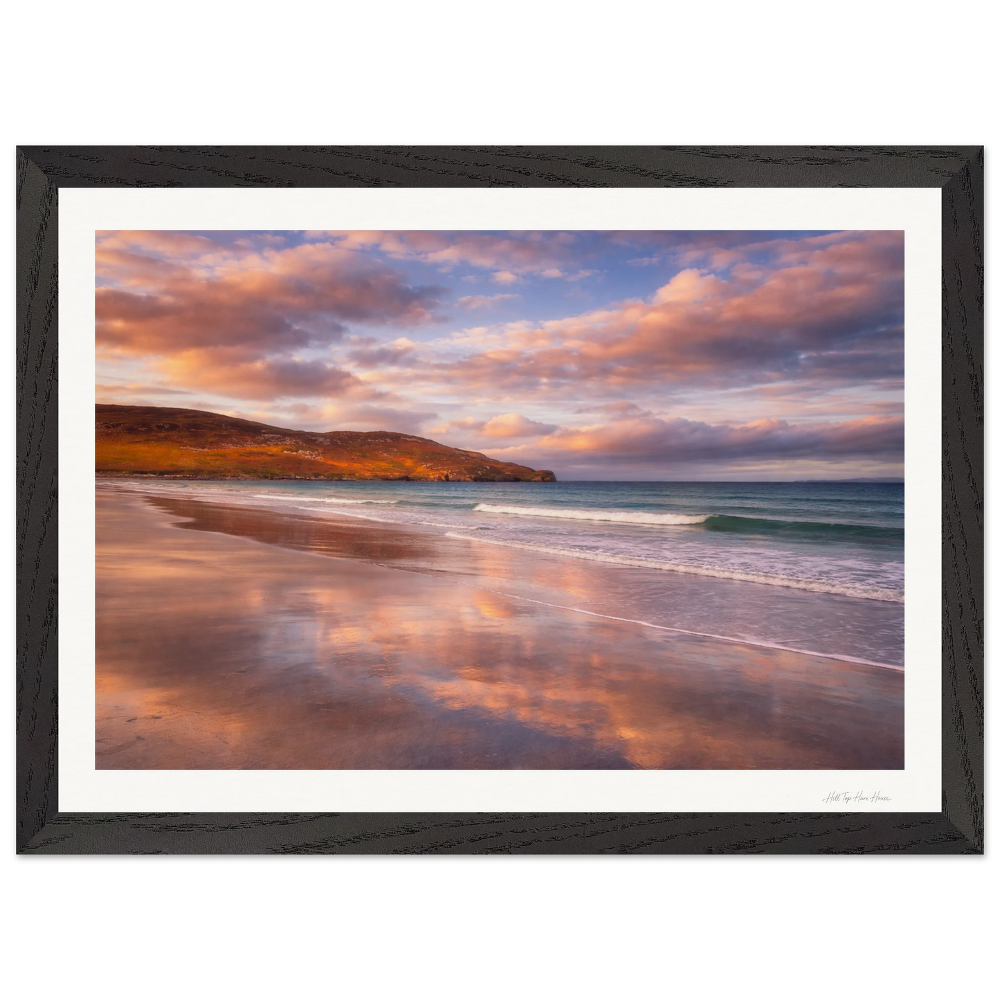 Framed artwork of a beach scene with a sunset reflection on the water.