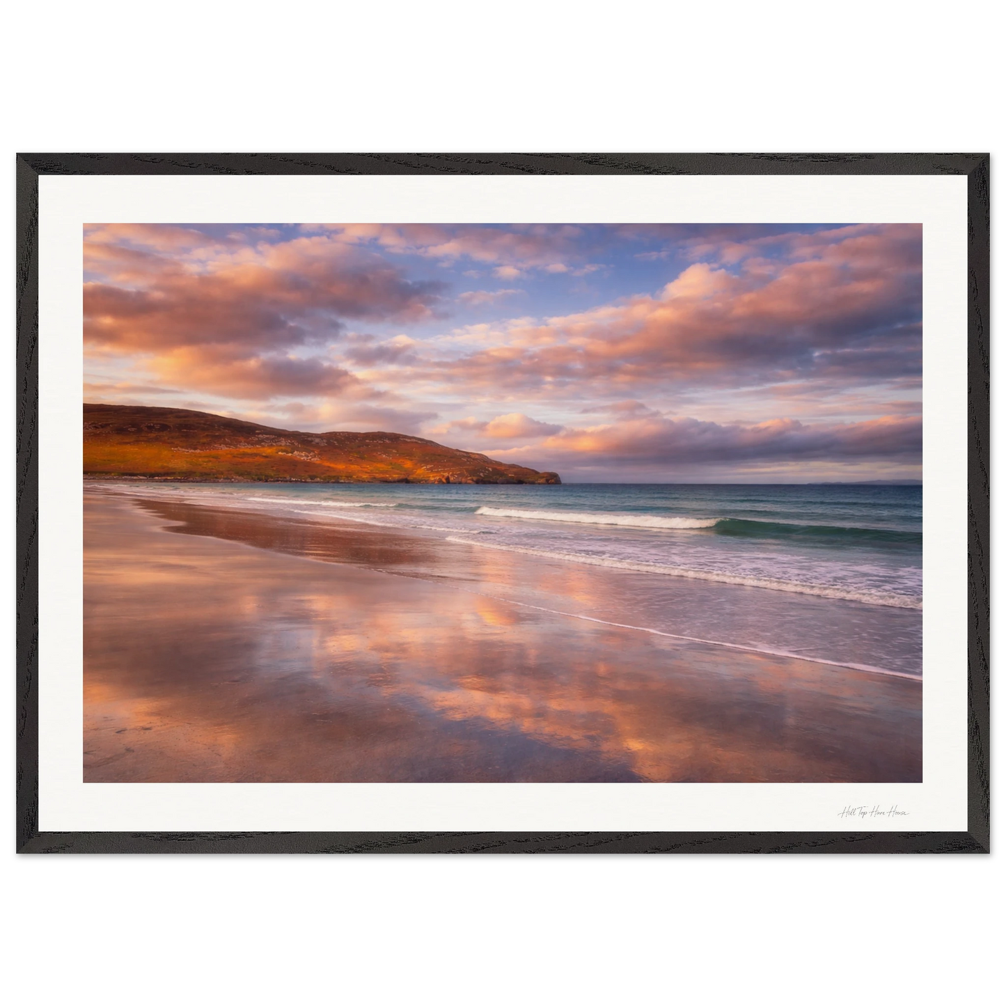 Framed artwork of a beach scene with a sunset sky.
