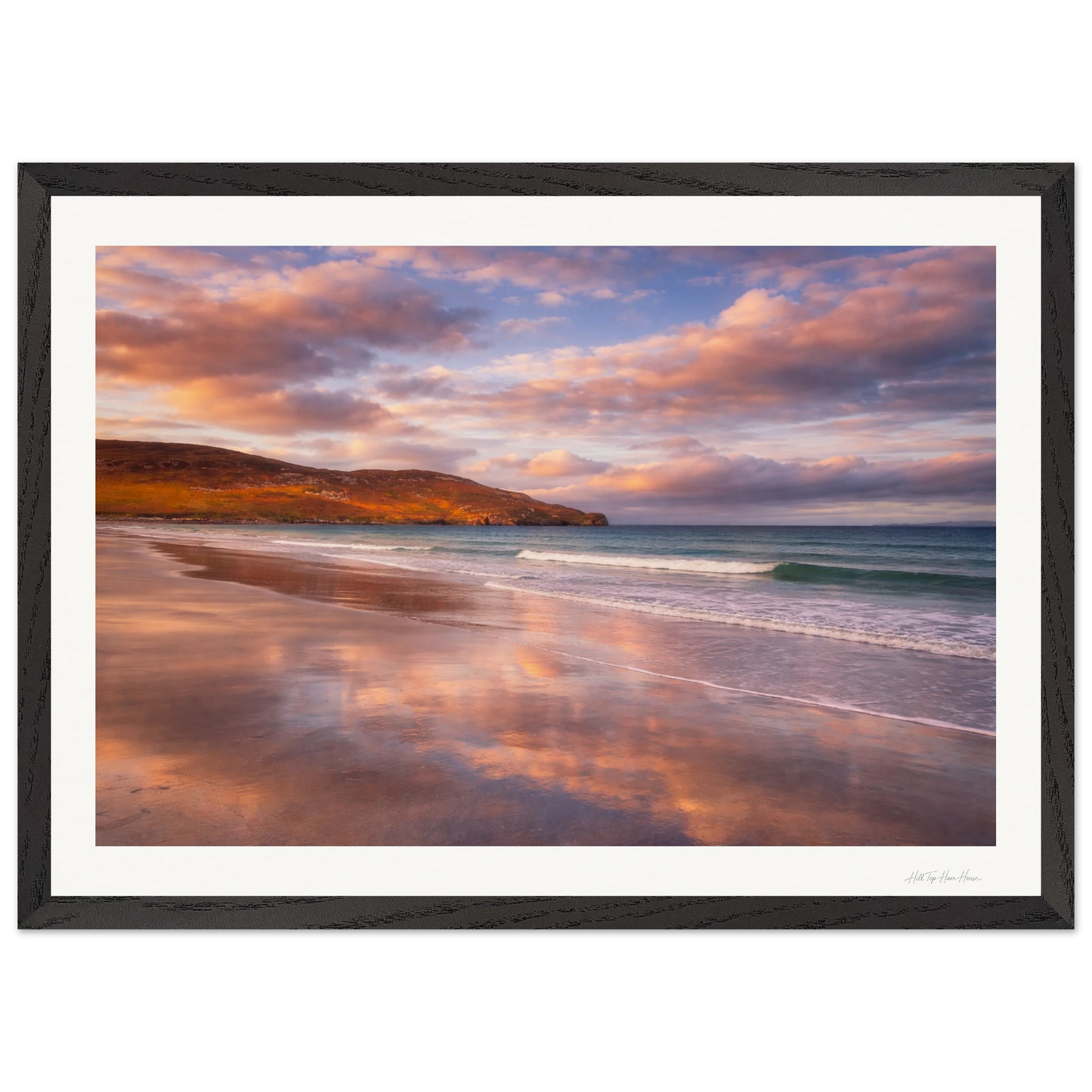 Framed artwork of a beach scene with a sunset over water and sky.