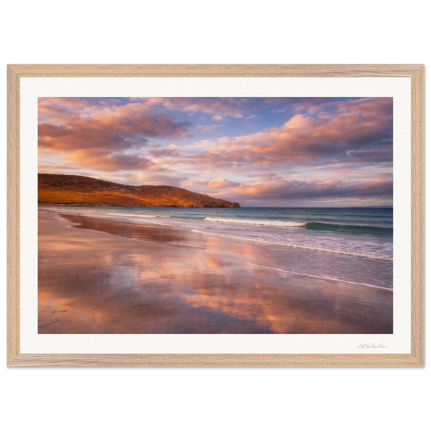 Framed artwork of a beach scene with a sunset sky.