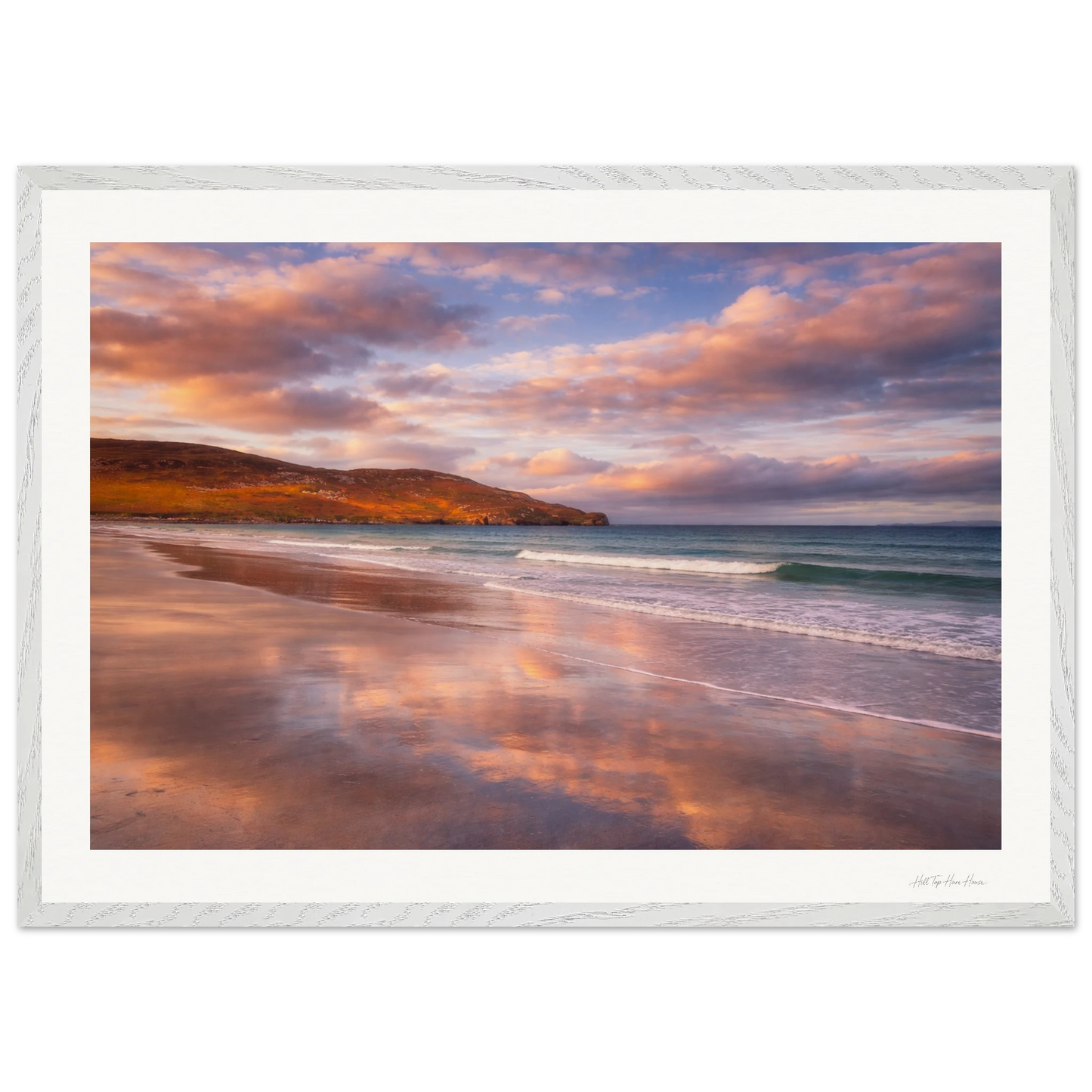 Framed artwork of a beach scene with a sunset over water and sky.