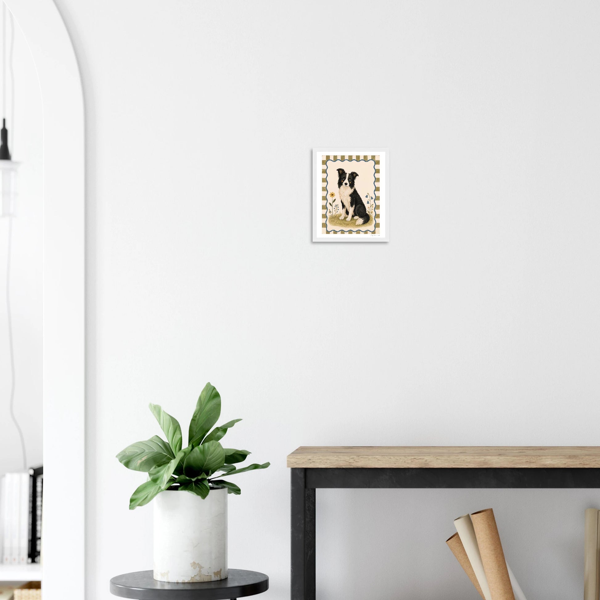 Small abstract painting on a white wall above a plant and desk.