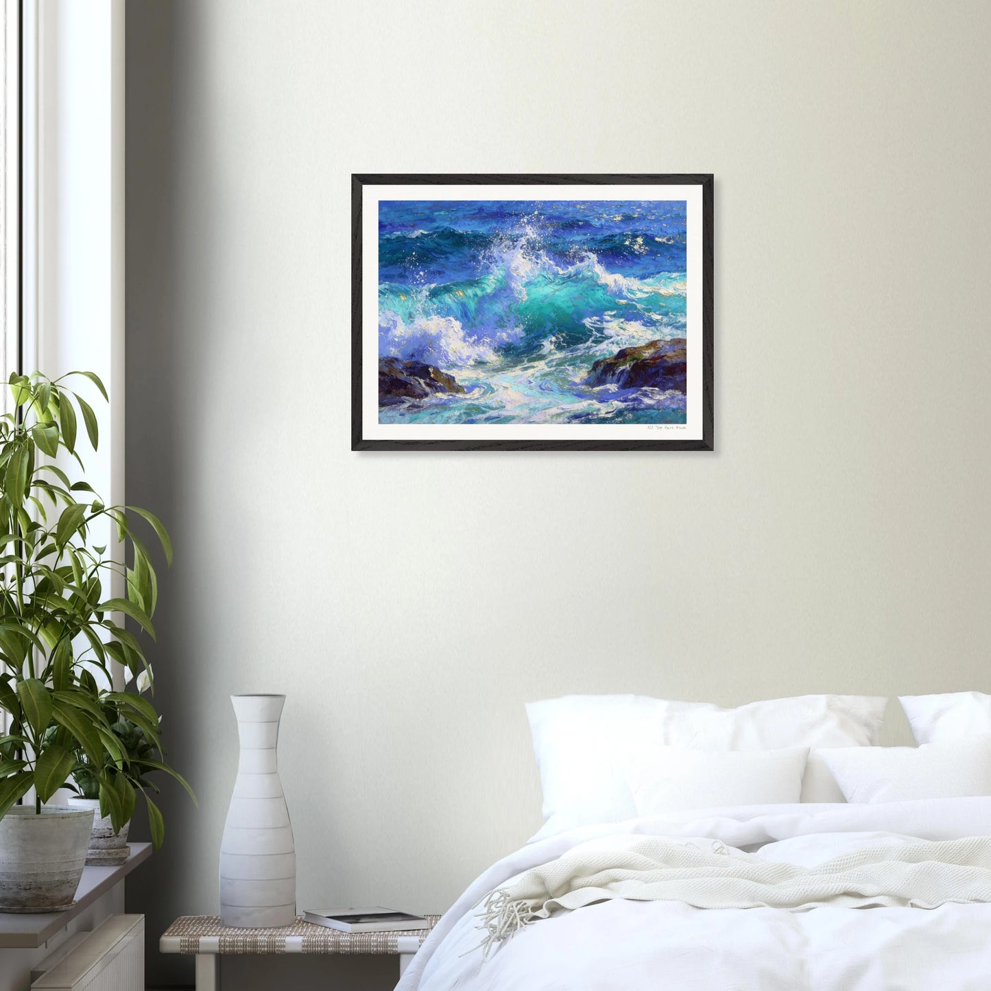 Framed artwork of a seascape with crashing waves on a wall above a bed.