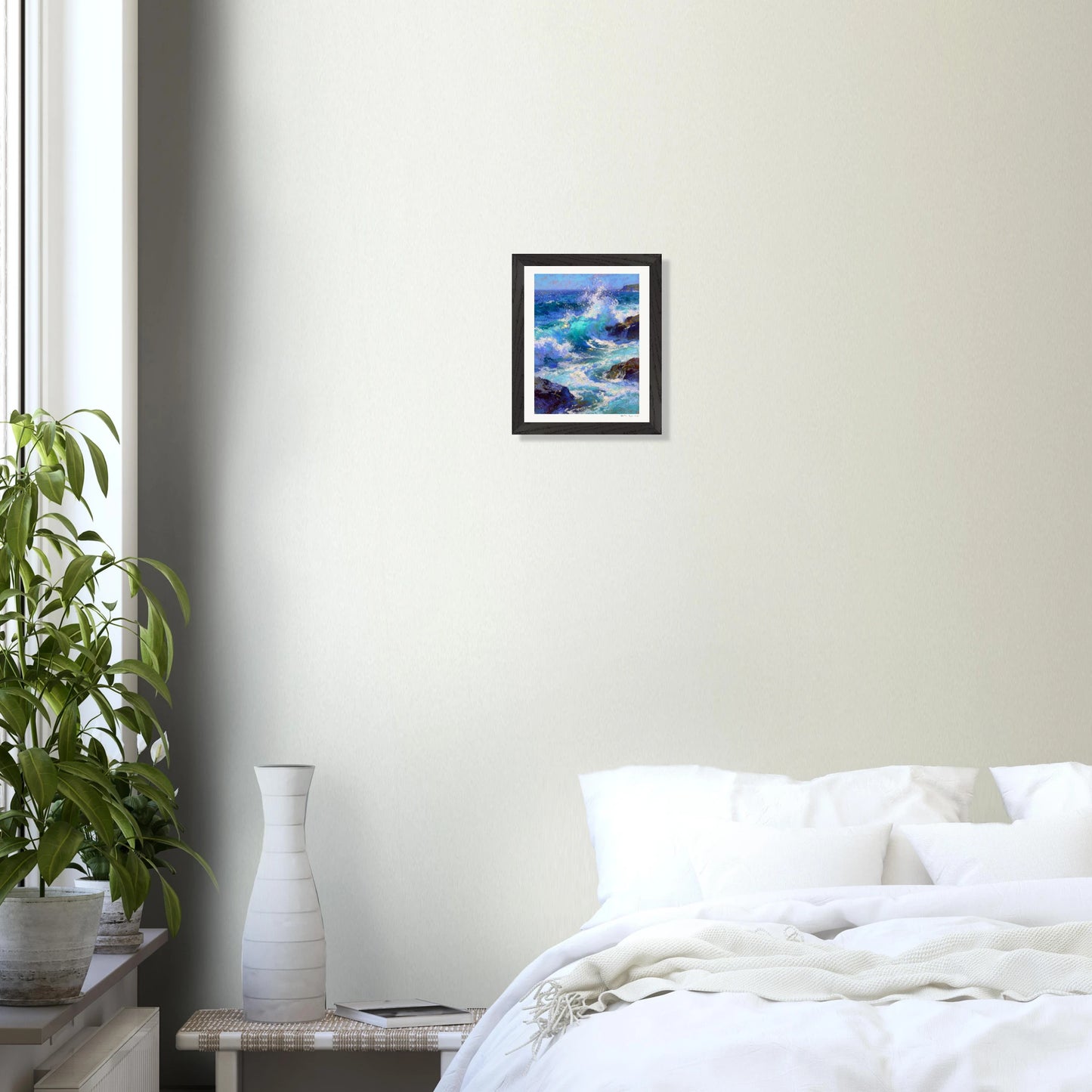 Framed artwork of donegal waves on a wall above a bed.
