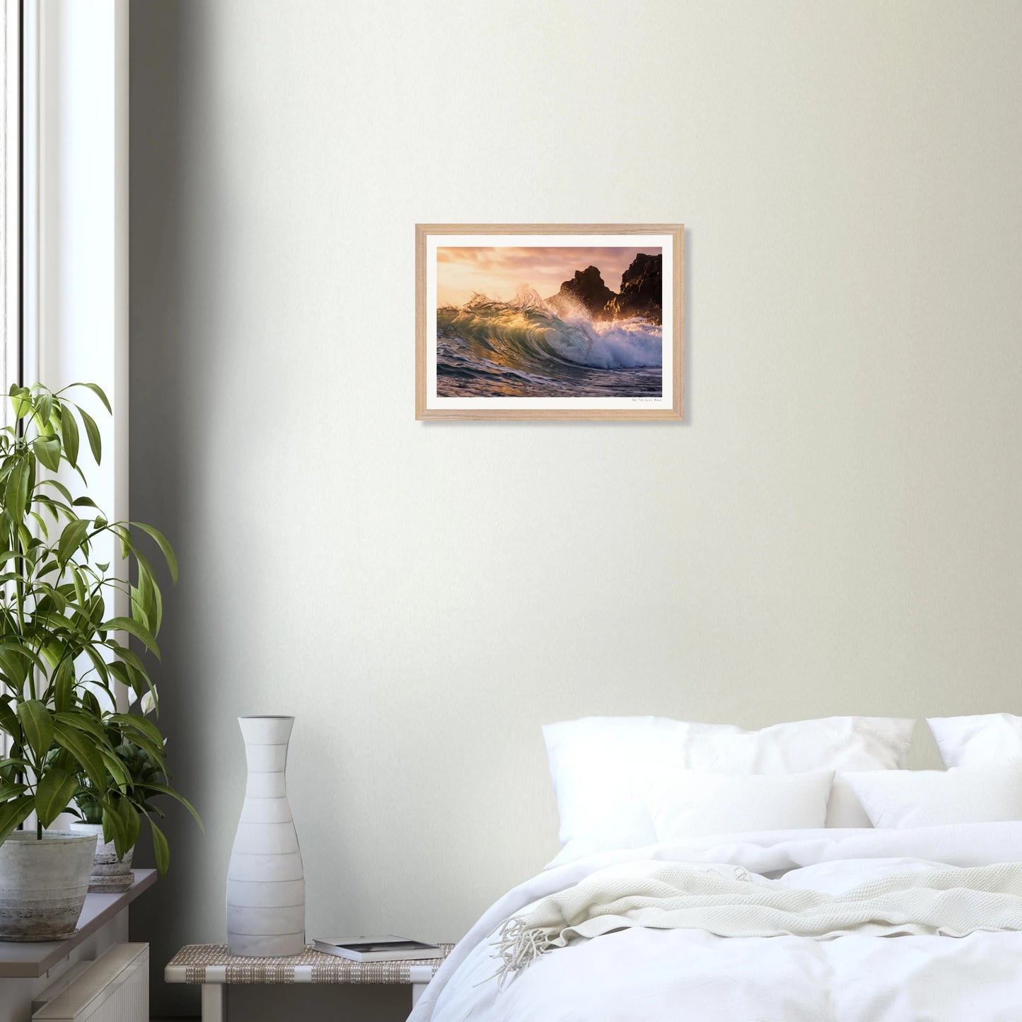 Framed artwork of a coastal scene above a bed in a bedroom.