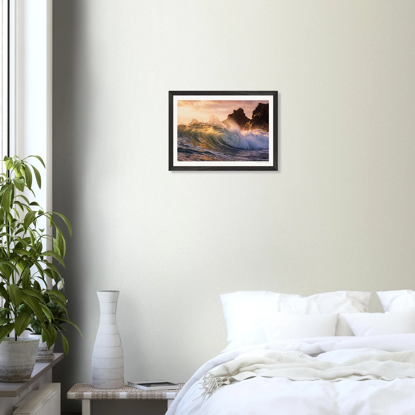 Framed artwork of a wave crashing on a beach in a bedroom setting.